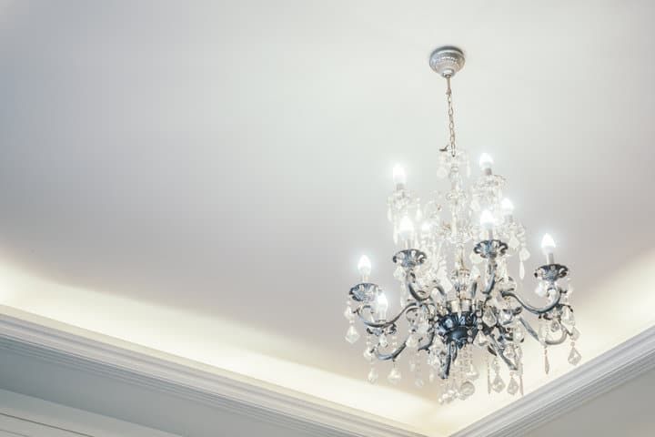 Elegant chandelier with multiple light bulbs and decorative crystals hanging from the ceiling.
