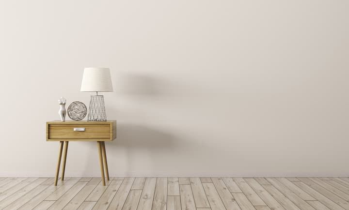 A stylish wooden side table with a lamp and decorative items.