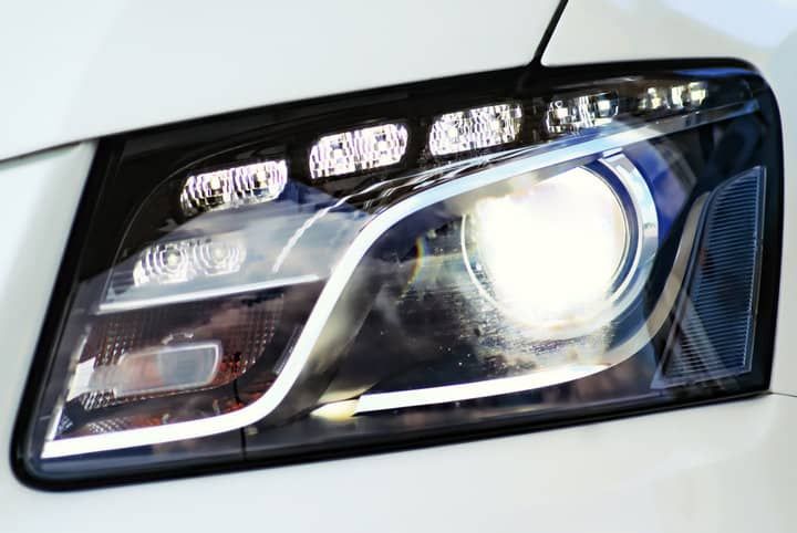 Close-up of a car's LED headlight, showcasing bright illumination and modern design.