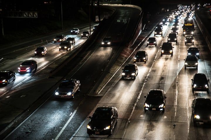 Busy highway at night with illuminated cars and roadways