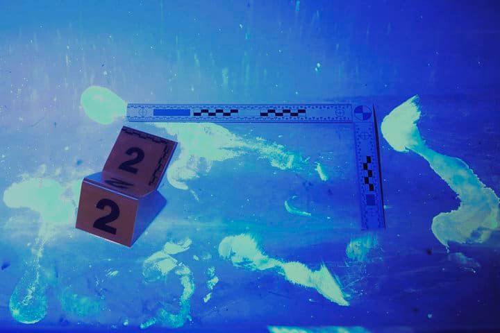 Two numbered evidence markers and a ruler on a glowing surface.