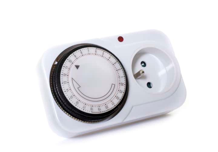White plug timer with dial for setting light schedules.