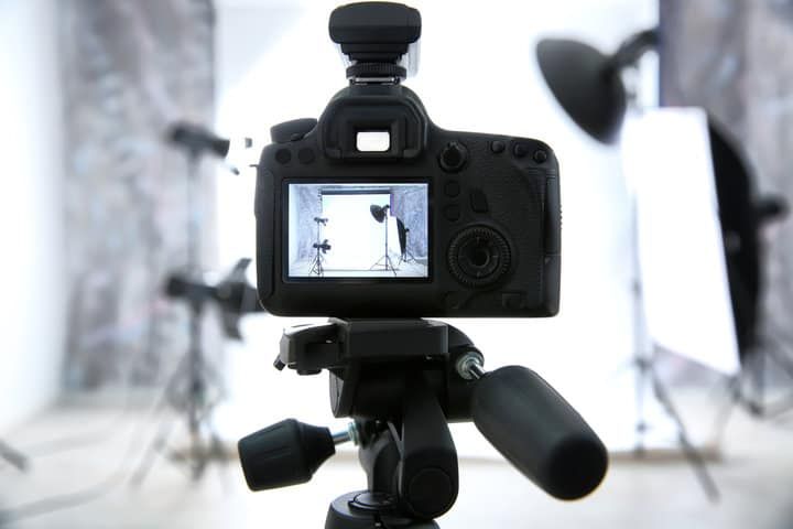 A DSLR camera focused on studio lighting equipment in a photography setup.