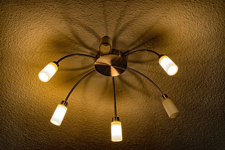 Stylish ceiling light fixture with four curved LED bulbs casting warm light.