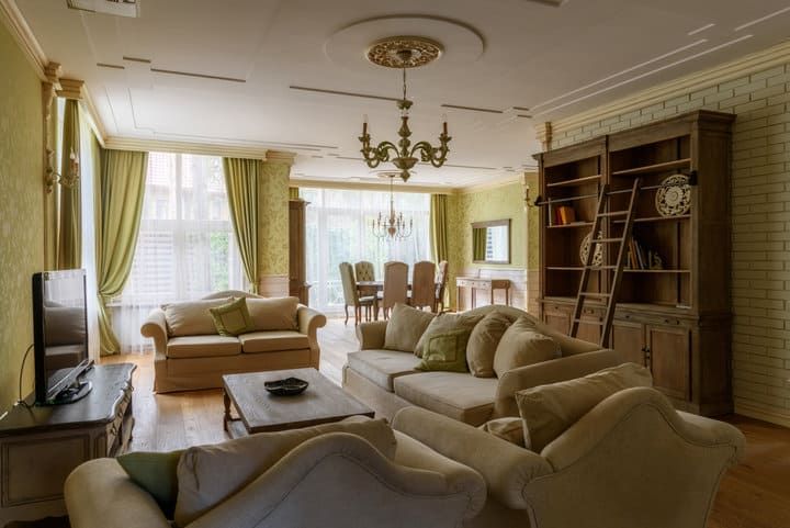 Spacious living room with soft sofas, elegant lighting, and large windows.