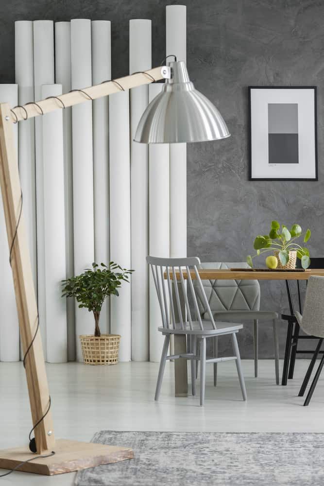 Stylish living space featuring a modern lamp, chairs, and greenery.