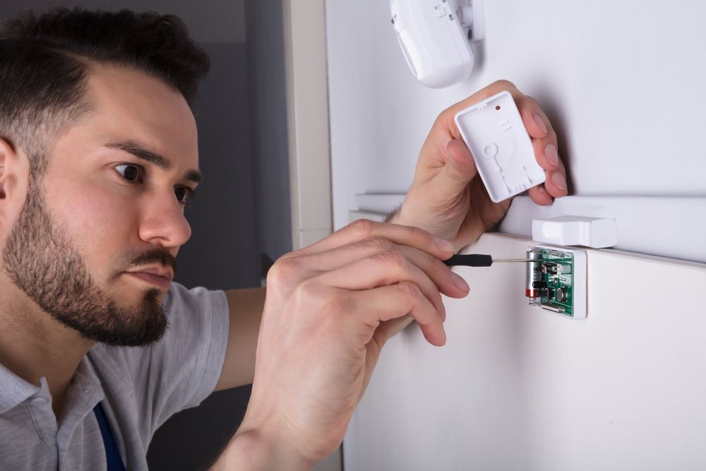 A technician is installing an LED light switch, using a screwdriver.