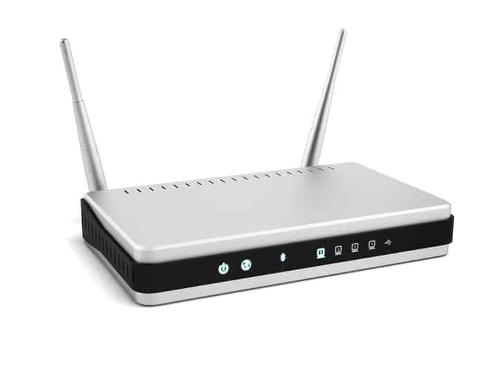 A modern silver router with antennas and indicator lights on the front