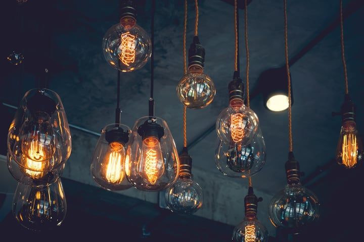 Various vintage LED light bulbs hanging from the ceiling with warm glow.