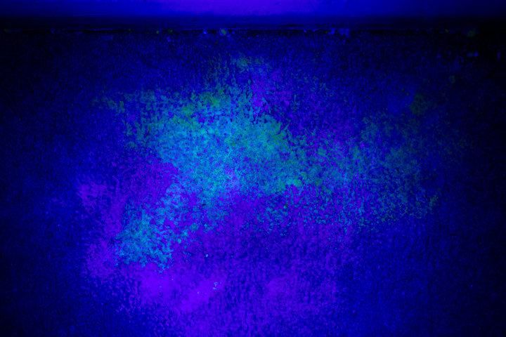 Vibrant blue and purple patterns splattered on a textured surface.