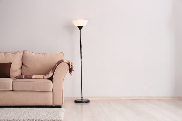 Cozy living room with a beige couch and a tall standing lamp.