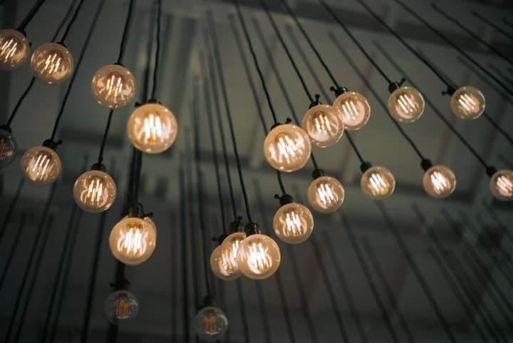 Warm glowing LED bulbs hanging from thin black wires in a modern setting.