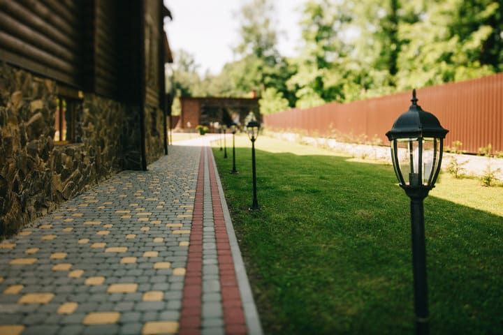 Pathway lined with decorative LED lamps alongside a green lawn.