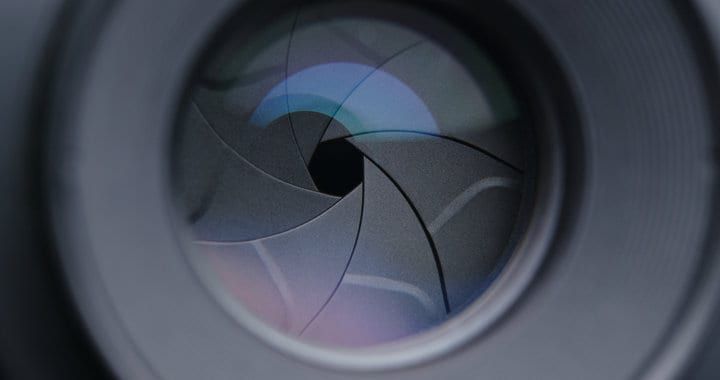 Close-up of a camera lens aperture blades arranged in a circular formation.