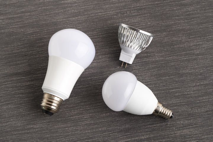 Three types of LED light bulbs in various shapes and sizes on a gray background.