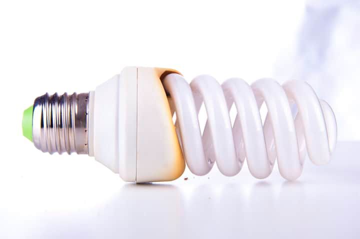 A compact fluorescent light bulb with a twisting design on a white background.