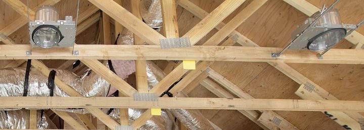 Wooden ceiling beams with LED spotlight fixtures and insulation visible
