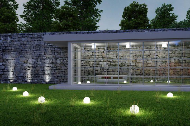 Modern outdoor space featuring LED lights illuminating a lush green lawn.
