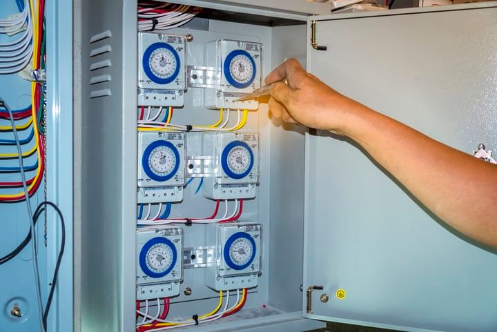 Hand adjusting timers inside a control panel for LED lighting systems.