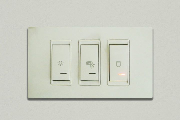 Wall switch panel featuring three different light controls, one illuminated.