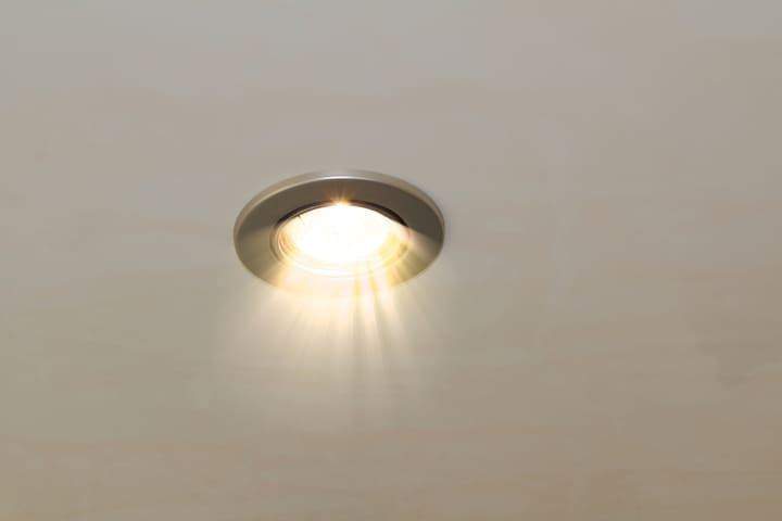 A recessed LED ceiling light illuminating a smooth beige surface.