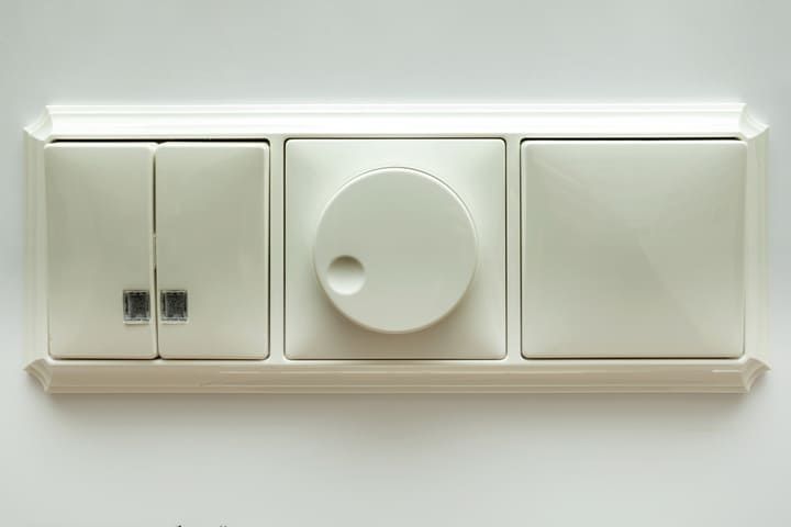 A white LED control panel with three controls, two switches and a dimmer.