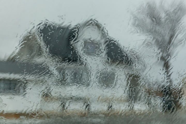 A blurry house seen through raindrops on a window.
