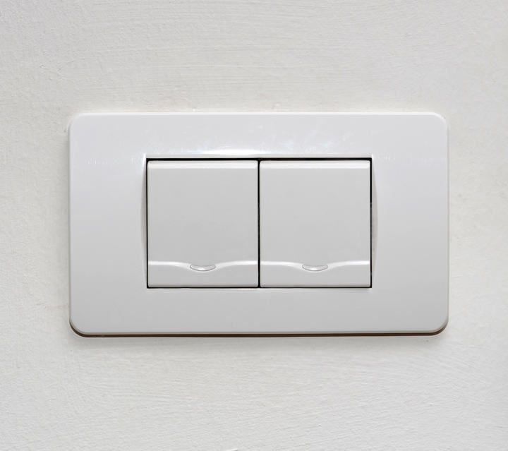A modern double light switch mounted on a white wall.