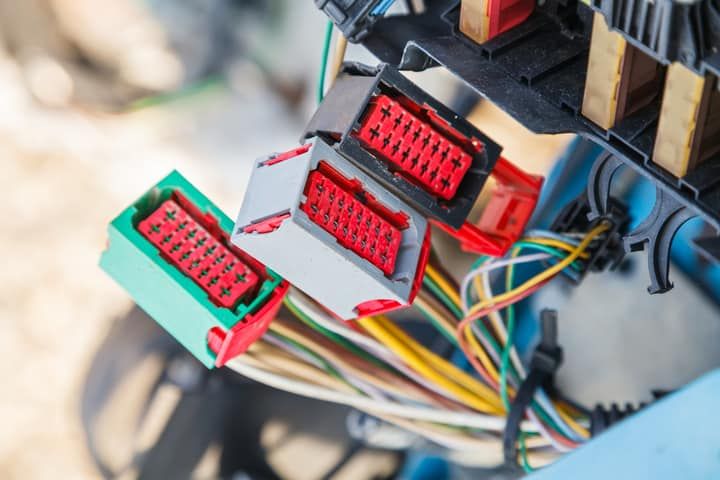 Close-up of electrical connectors with red and green components and colorful wires.