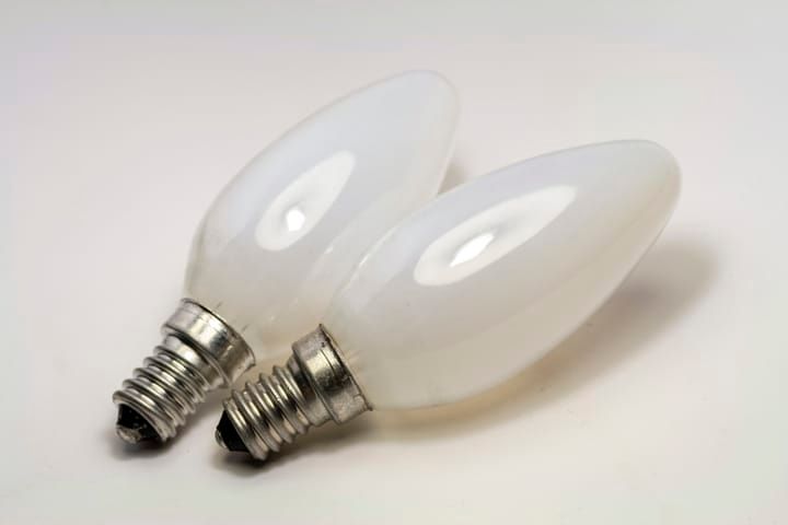 Two white LED light bulbs with a decorative shape and metal bases.