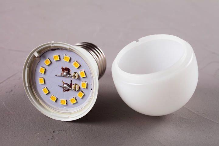 A broken LED light bulb with visible components inside and an outer shell.
