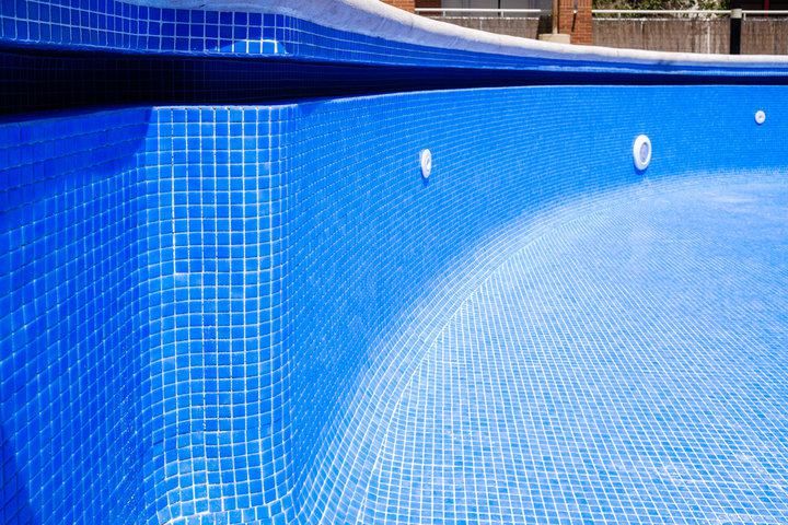 Close-up of a tiled swimming pool with vibrant blue water.