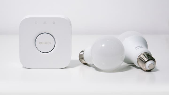 A smart LED bulb and control device displayed on a white surface.