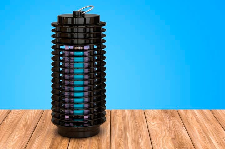 A modern black LED lamp on a wooden surface with colorful light inside.