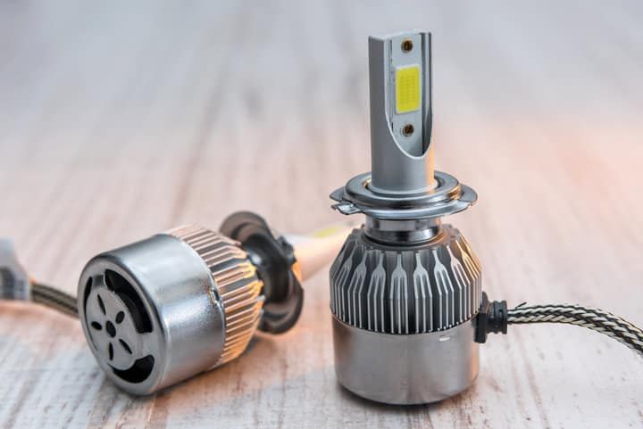 Two LED light bulbs on a wooden surface, showcasing their designs.