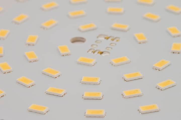 Close-up of a circular LED plate with multiple yellow light chips.