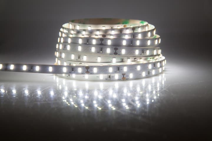 Coiled LED light strip with bright white lights, reflecting on a surface.