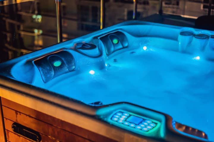 A hot tub with glowing blue LED lights and bubbling water.