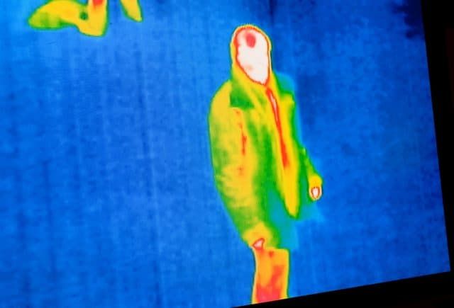 Thermal image showing a person in colorful heat map attire.
