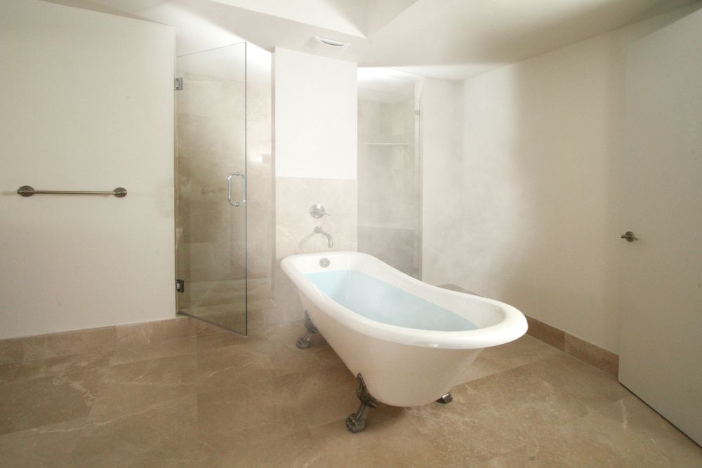 Bright, modern bathroom featuring a freestanding bathtub and glass shower.