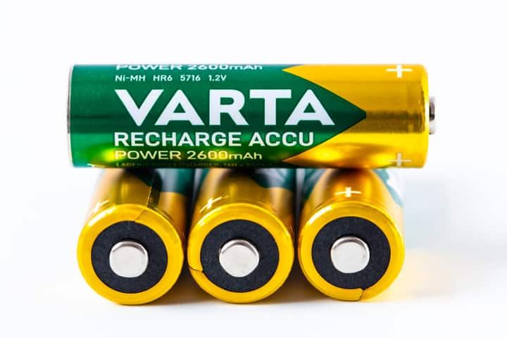 Four Varta rechargeable batteries stacked with positive terminals facing up.