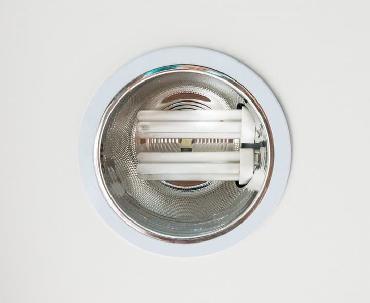 A round recessed LED light fixture with white casing and frosted bulbs.