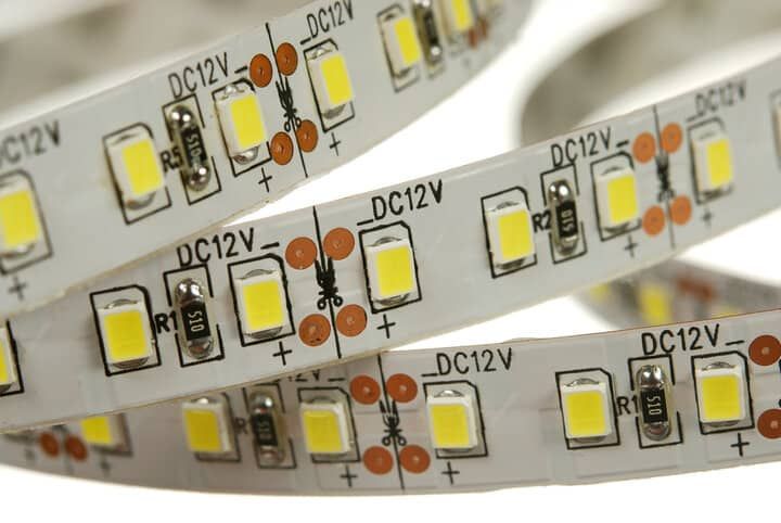 Close-up of flexible LED strip lights with yellow bulbs and circuit markings.