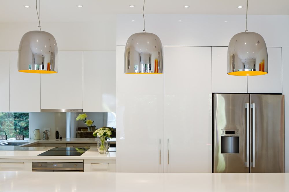 Sleek kitchen with modern pendant lights and stylish stainless steel appliances.