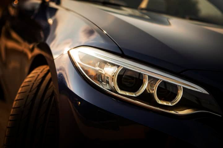 Close-up view of a car's stylish LED headlights and tire.