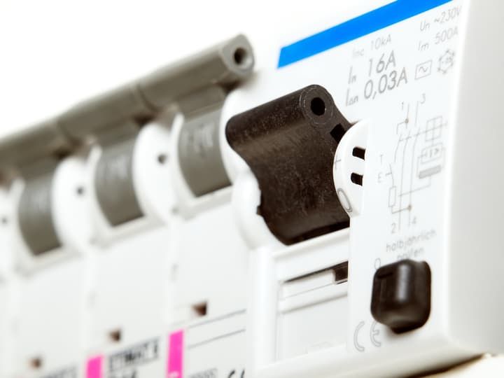Close-up of a circuit breaker with various electrical ratings and labels.