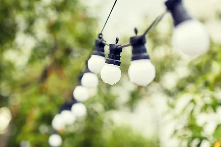 A string of LED lights hanging against a blurred green background.