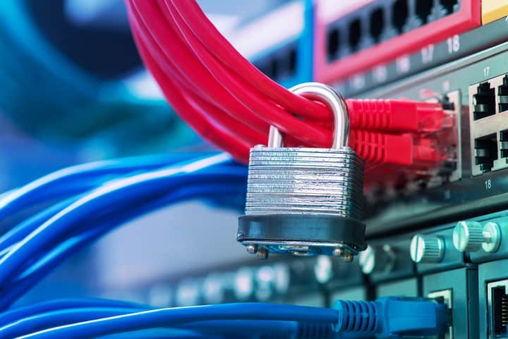 Colorful network cables connected to a switch, secured with a padlock.