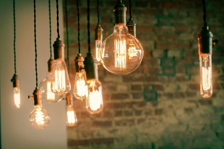 Hanging vintage-style LED bulbs illuminating a rustic brick wall.