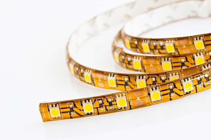 Colorful LED light strips coiled on a white surface.